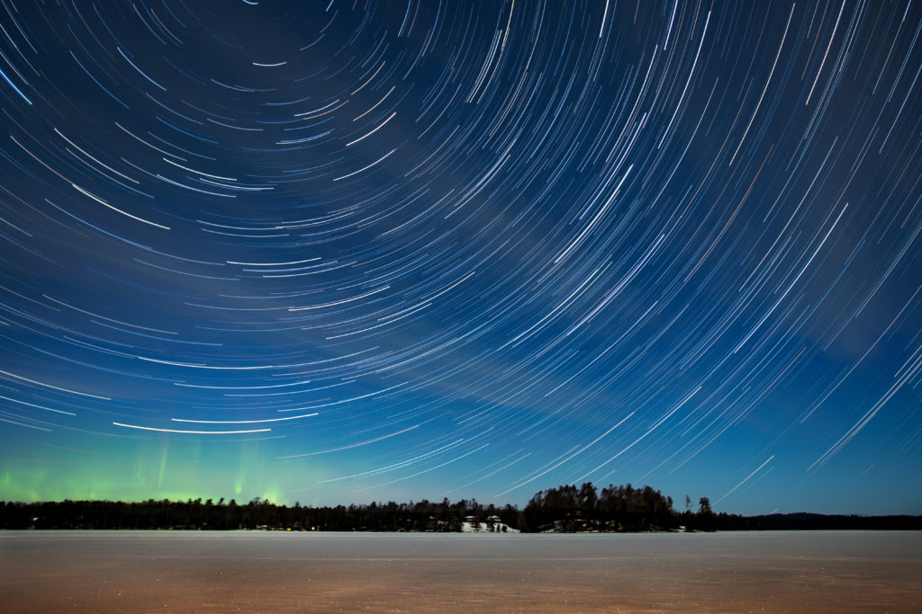 Northern lights and star trails over wintry Plum Lake