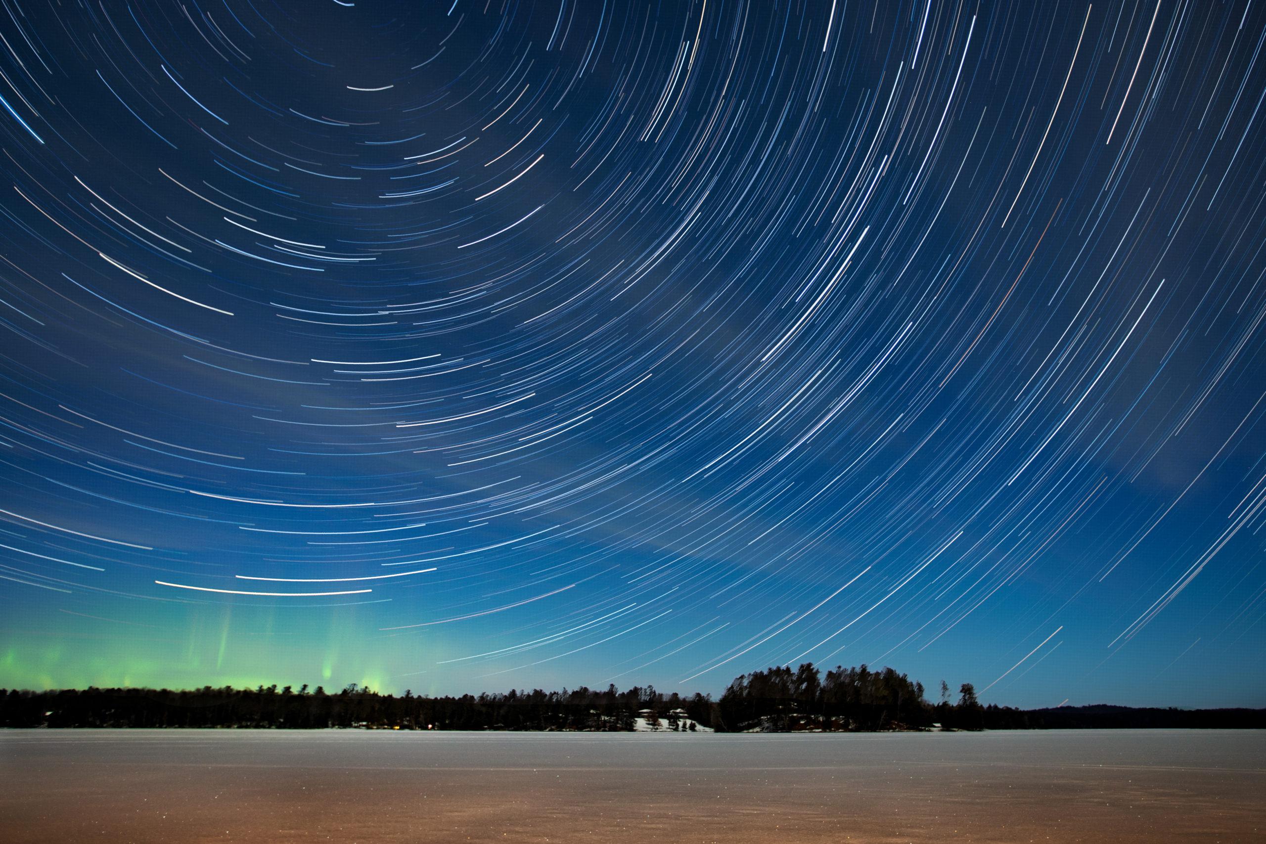 Northern lights and star trails over wintry Plum Lake